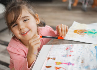 Sinequias vulvares: qué son y cuándo tratarlas Joyful child engaged in colorful art project at home