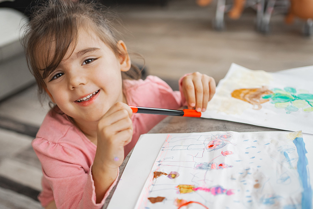 Joyful child engaged in colorful art project at home