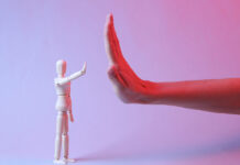 Más de 14.000 farmacias en España detectan casos de violencia de género High-five female hand and puppet in red blue neon light
