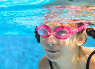 Cuidado ocular: más allá de la zanahoria Child swims in pool underwater, happy active girl in goggles has fun in water, kid sport on family vacation