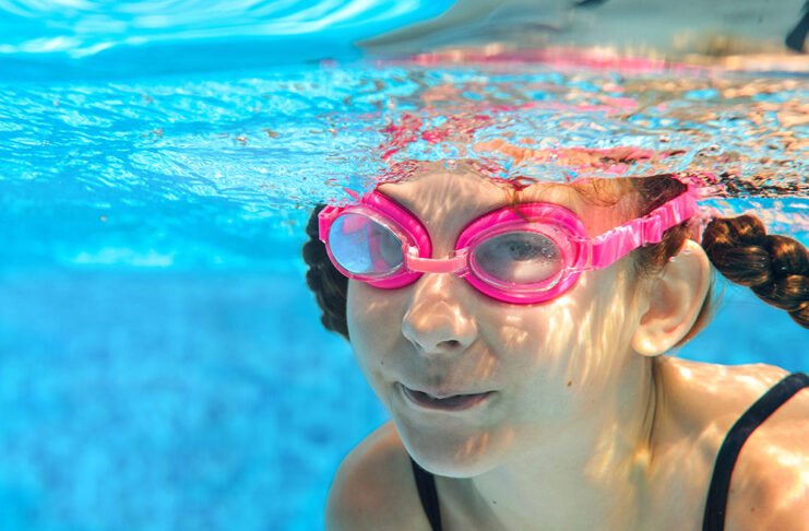 Cuidado ocular: más allá de la zanahoria Child swims in pool underwater, happy active girl in goggles has fun in water, kid sport on family vacation