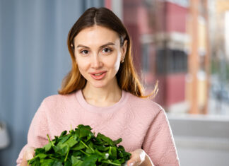 El magnesio como mineral esencial para nuestro organismo Smiling girl eating green salad at home