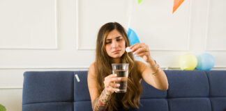 Los farmacéuticos alertan sobre los riesgos de los kits antiresaca riesgos kits antiresaca Sick young woman suffering nausea and hangover taking medicine after drinking a lot of alcohol at a party