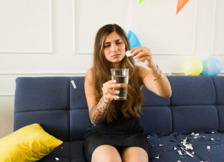 Los farmacéuticos alertan sobre los riesgos de los kits antiresaca riesgos kits antiresaca Sick young woman suffering nausea and hangover taking medicine after drinking a lot of alcohol at a party