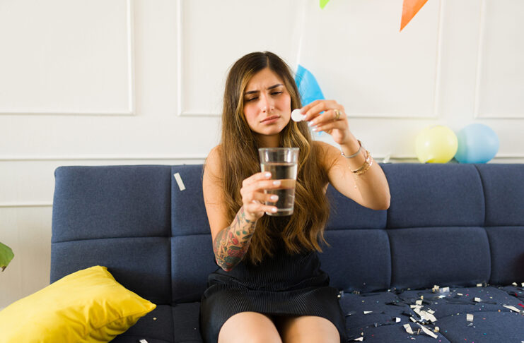 Los farmacéuticos alertan sobre los riesgos de los kits antiresaca riesgos kits antiresaca Sick young woman suffering nausea and hangover taking medicine after drinking a lot of alcohol at a party